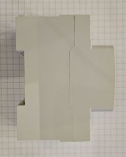 Side view of a gray mounting module placed on grid paper