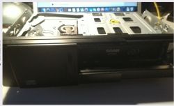 Odtwarzacz CD samochodowy marki Saab otwarty w celu sprawdzenia podłączeń.