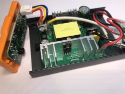 Otwarta obudowa stacji lutowniczej z widoczną płytką drukowaną, zasilaczem impulsowym, przewodami i elementami elektronicznymi.