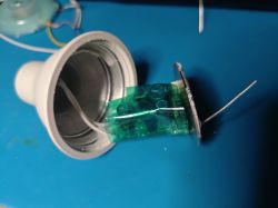 Open Lamp Holder with Wires Close-up view of an open plastic lamp holder with wires and green insulating material inside.