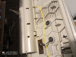 Żółty kabelek wewnątrz obudowy elektronicznego urządzenia, prawdopodobnie radia