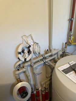 Instalacja hydrauliczna z rurami i przewodami na ścianie.