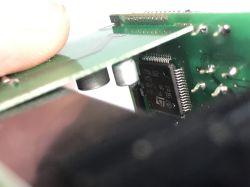 Zbliżenie na płytkę drukowaną z widocznym układem scalonym oraz elementami elektronicznymi.