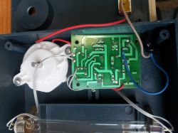 Widok wnętrza urządzenia elektronicznego z płytką drukowaną i okablowaniem.