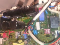 Zbliżenie na płytę główną suszarki z elementami elektronicznymi i kablami.