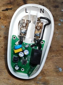 Wnętrze wyłącznika elektrycznego z oznaczeniami L i N na przewodach.