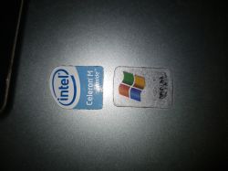Naklejki Intel Celeron M oraz Windows na powierzchni laptopa.