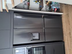 Czarna lodówka w zabudowie kuchennej z boczną wnęką na produkty