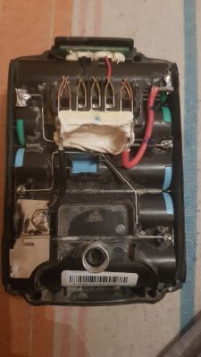 Wnętrze baterii ładowarki DCB105 z widocznymi podzespołami elektrycznymi.
