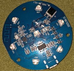 Round blue PCB with LEDs, ICs, SMD components, and visible circuit traces.
