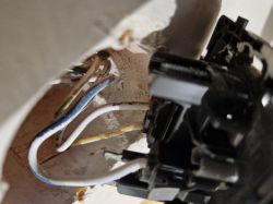 Instalacja elektryczna z widocznymi przewodami w ścianie.