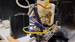 Zbliżenie na podłączenie elektryczne agregatu lodówkowego z widocznymi kolorowymi przewodami i złączkami.