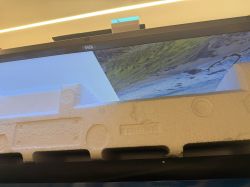 Xiaomi TV with Styrofoam Transport Protection on Screen Top edge of a Xiaomi TV with partial screen image and styrofoam transport protection in place.