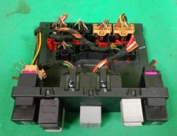 Zdjęcie modułu sterowania samochodowego z różnymi wtyczkami i przewodami.