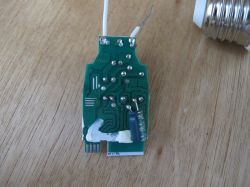 Printed circuit board with electronic component on a wooden surface.