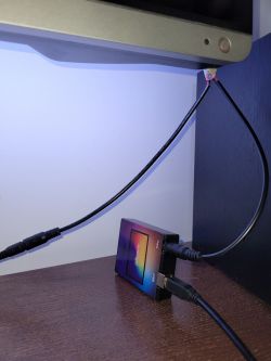 LED controller connected to a TV and power supply on a shelf.