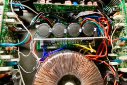 Wnętrze wzmacniacza z widocznymi elementami elektronicznymi i okablowaniem.