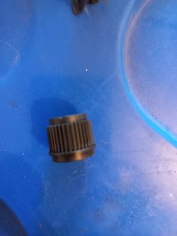 Metalowy element mechanizmu na niebieskim tle.