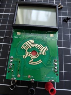 Internal Components of a Multimeter with Disassembled PCB Inside view of a disassembled multimeter showing PCB and switch tracks.