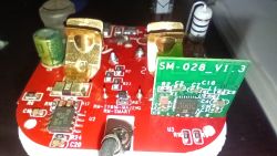 Close-up of a printed circuit board with electronic components on a red background.