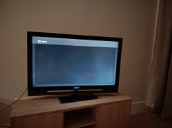 Telewizor Sony na szafce, na ekranie ciemny obraz z jaśniejszą obwódką przy krawędziach