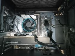 Wnętrze komputera PC z widocznymi komponentami: karta graficzna Sapphire, płyta główna MSI, wentylator procesora Intel, pamięci RAM oraz okablowanie.