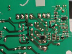 Image of a green printed circuit board with visible markings of components and vias.