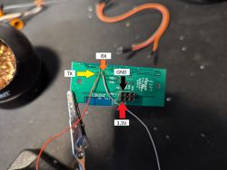 Close-up of a circuit board with labeled TX, RX, GND, and 3.3V pins.