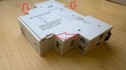 White “WiFi Smart Time &amp; Meter” module on a wooden surface, with red arrows pointing to parts