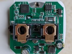 Top view of a PCB with electronic components and two metal holders.