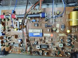 Zdjęcie wnętrza urządzenia elektronicznego z widoczną płytką obwodów z różnymi komponentami elektronicznymi.