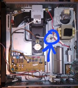 Wnętrze urządzenia z zaznaczonym wyłącznikiem termicznym.