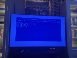 Telewizor wyświetlający ekran startowy Commodore 64 z wprowadzonym programem w języku BASIC.