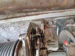 Widok mechanizmu z ręczną blokadą zabezpieczoną gwoździem.