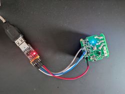 USB UART adapter connected to a circuit board with glowing LEDs