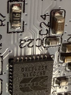 Macro photo of a PCB with a Beken IC and SMD parts; marking “C24” is visible.