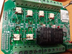 Close-up of an electronic circuit board with components, including MOSFET relays and screw terminals.
