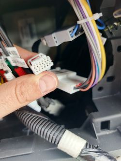 Zbliżenie na 12-pinową kostkę przewodów w desce rozdzielczej Nissana Juke