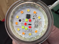 Close-up of the interior of an LED bulb with colorful diodes and an integrated circuit.