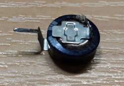 Mała bateria guzikowa z metalowymi stykami.