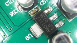 Nahaufnahme einer Leiterplatte mit einem sichtbaren AMS1117-Chip und elektronischen Bauteilen.