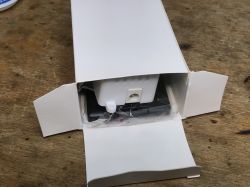 Opened LED Controller Package Opened package of LED strip controller on a wooden table.