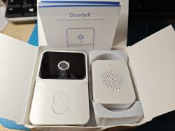 Video doorbell and receiver in an open box on a desk