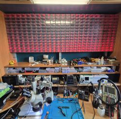 A fully equipped workshop station with a microscope and electronic tools.