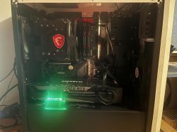 Widok wnętrza obudowy komputera z zainstalowaną kartą graficzną Gigabyte RTX 3070 Ti i podzespołami MSI.