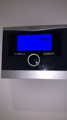 Sterownik Vaillant z niebieskim ekranem wyświetlającym informacje o temperaturze.