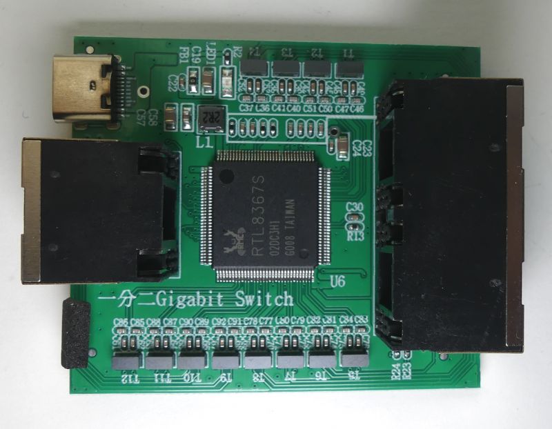 Zdjęcie wnętrza przełącznika sieciowego RTL8367S z trzema portami Ethernet.