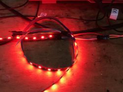Red LED Strip Connected on a Table Individually addressable LED strip glowing red on a table.