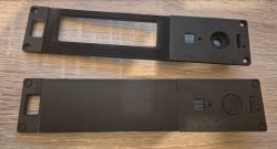 Two black prototype front panels with cutouts for screen and buttons