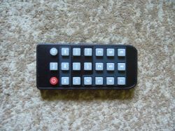 Remote control with buttons on a brown background.